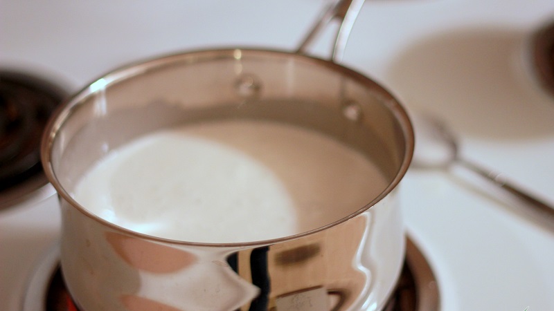 Đun nóng sữa bằng bếp gas với lửa nhỏ để tránh sữa sôi