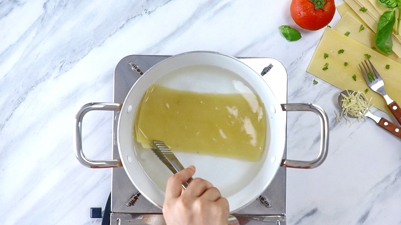 Cho những lá mì lasagne đi luộc rồi bỏ vào nước lạnh để khỏi dính vào nhau