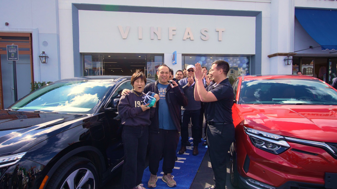 Bà Nicole Wang (cầm hộp quà) là vị khách đầu tiên nhận chiếc VF 8 tại một showroom của VinFast ở Mỹ.