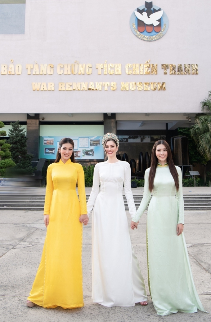 Ngày 2/3, Isabella Menin mặc áo dài của nhà thiết kế Ngô Nhật Huy thăm Bảo tàng Chứng tích chiến tranh. Cô chụp ảnh cùng hoa hậu Đoàn Thiên Ân (trái) và á hậu Quỳnh Châu (phải).