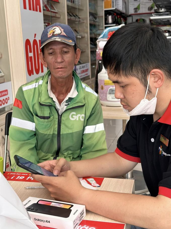 Anh Lang được một mạnh thường quân dẫn đi mua tặng chiếc điện thoại mới tại một cửa hàng ở Đà Nẵng, chiều 4/4. Ảnh: Hoai Nguyen
