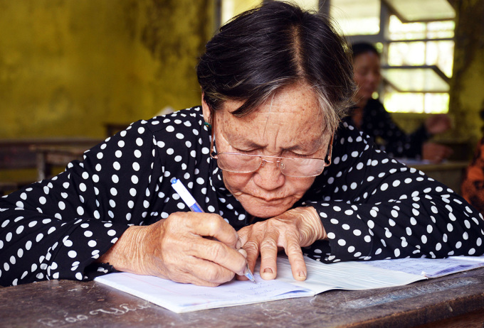 Bà Nguyễn Thị Thao tập viết chữ tại lớp học. Ảnh: An Minh