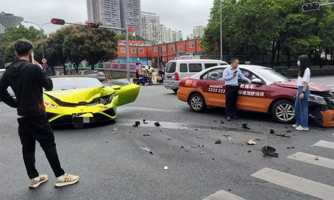 Tài xế siêu xe (mặc đồ đen) đang gọi điện, trong khi đứng cạnh xe dạy lái là một người đàn ông (có thể là giáo viên dạy lái) và một cô gái. Ảnh: Weibo