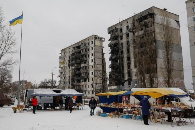 Người dân mua thực phẩm tại khu chợ trước một tòa chung cư ở Kyiv tháng 12/2022. Ảnh: Reuters