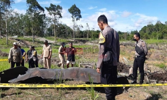 Cảnh sát Indonesia kiểm tra một mảnh vỡ của tên lửa Trường Chinh 5B tại làng Pengadang, Tây Kalimantan. Ảnh: Borneo Post