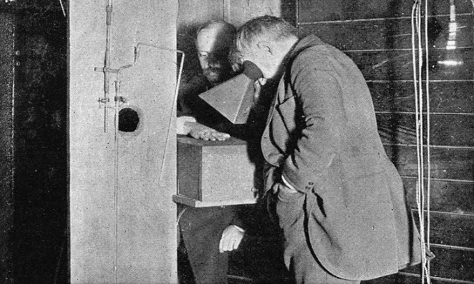 Edison nhìn qua kính huỳnh quang để quan sát tia X rọi vào bàn tay của Clarence Madison Dally. Ảnh: Wellcome Images