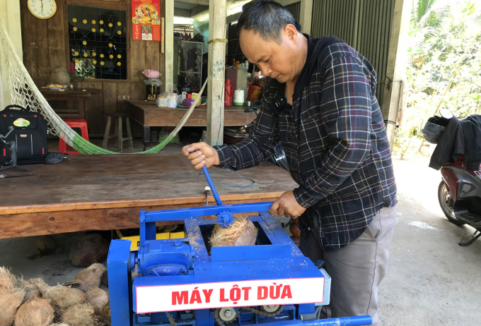 Anh Nguyễn Văn Mạnh trình diễn máy lột vỏ dừa do mình sáng chế. Ảnh: Huỳnh Văn Xĩ.