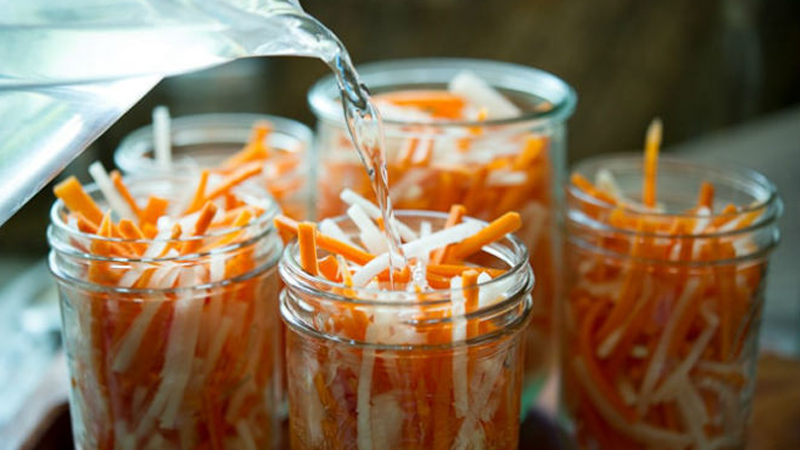 Rót nước giấm vào hũ củ cải và cà rốt