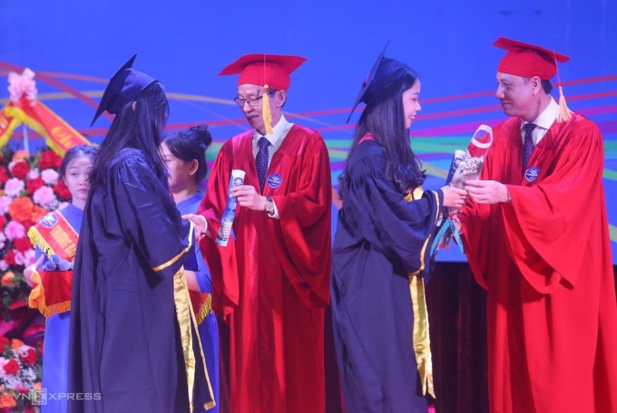Lãnh đạo Đại học Sư phạm Hà Nội trao cuốn thư và hoa mừng tốt nghiệp cho các tân cử nhân. Ảnh: Duy Tâm